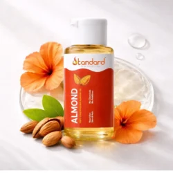 Cold pressed almond oil bottle with almonds and hibiscus flowers for skin and hair care