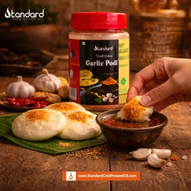 Garlic podi served with idli and sesame oil on a wooden table, traditional South Indian breakfast with spicy chutney powder