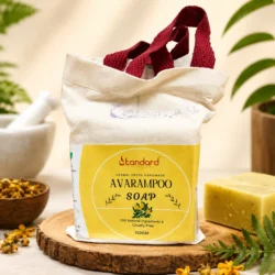 Handmade Avarampoo soap bar with eco-friendly packaging placed on a wooden table with herbal ingredients and natural background.