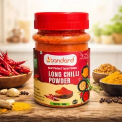 Long chilli powder bottle with natural spices ingredients on wooden background