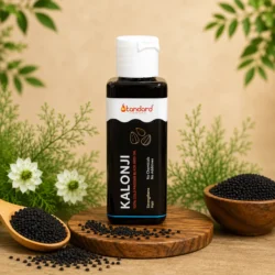 Pure cold pressed Kalonji oil bottle with black seeds and natural ingredients background