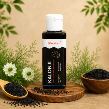 Pure cold pressed Kalonji oil bottle with black seeds and natural ingredients background